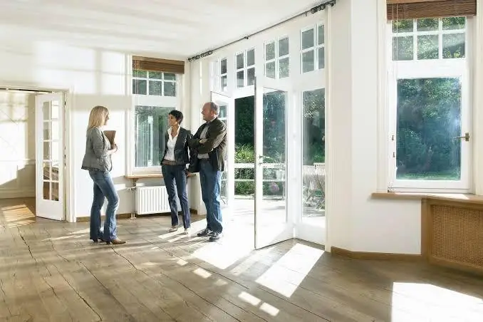 A HomeBliss agent consulting with sellers in a bright, open room