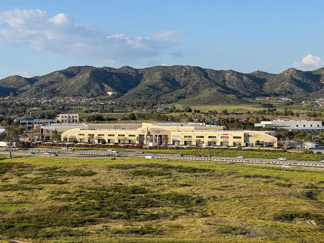Looking east across Interstate 15 at Wildomar, California, with retail along the freeway and open land in the foreground
