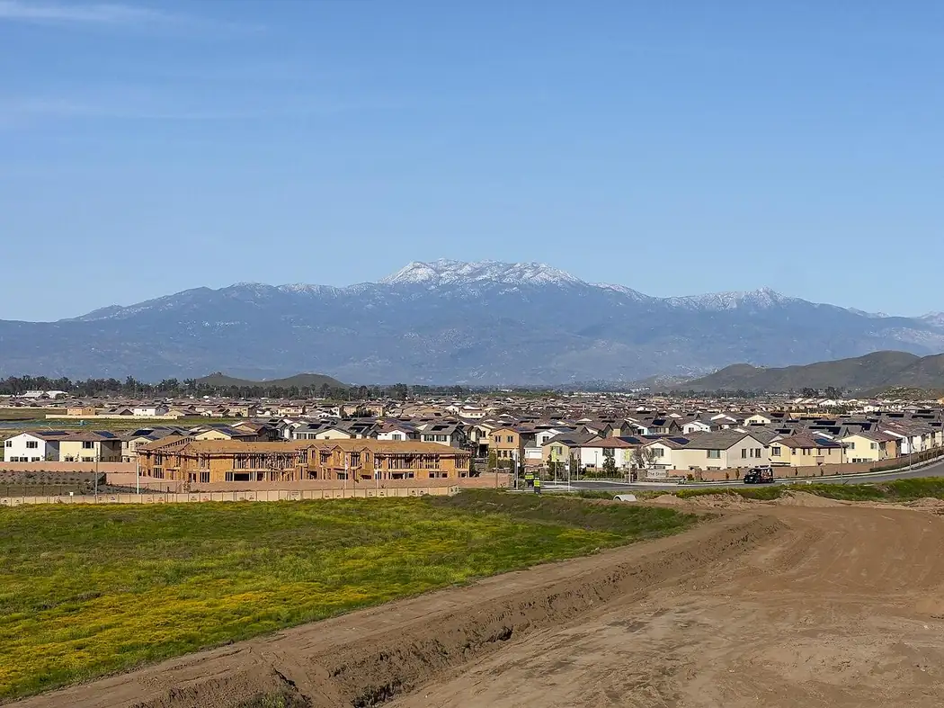 New homes under construction in Winchester, California, with the snow-capped San Jacinto mountains behind them